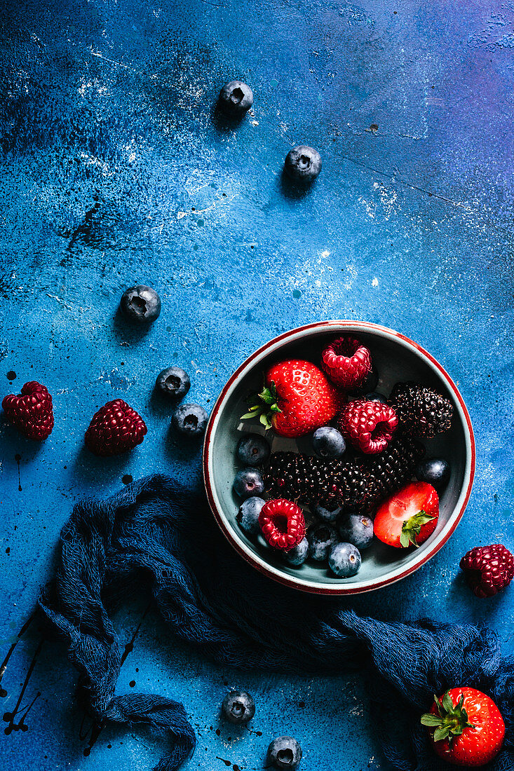 Stillleben mit Waldfrüchten auf blauem Hintergrund