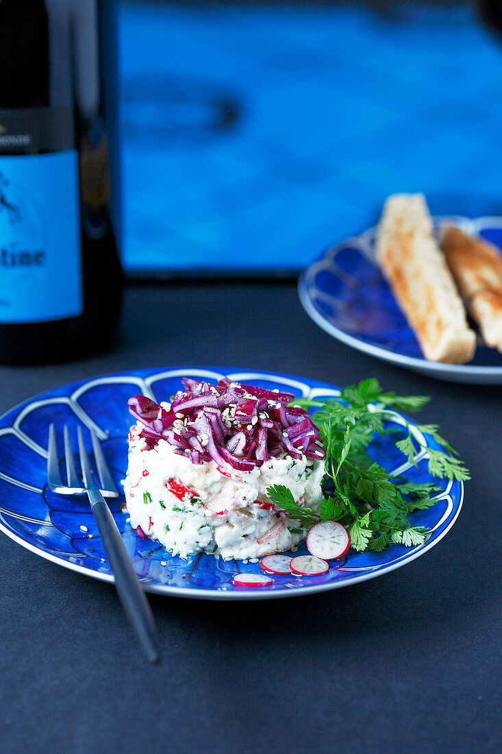 Fromage frais mixed with chopped radishes and chives timbale topped with grated red cabbage and sesame seeds