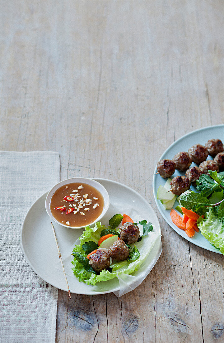 Frühlingsrolle mit Reispapier, Salatblatt und Fleischbällchen zubereiten, Schälchen scharfe Sauce mit Erdnüssen