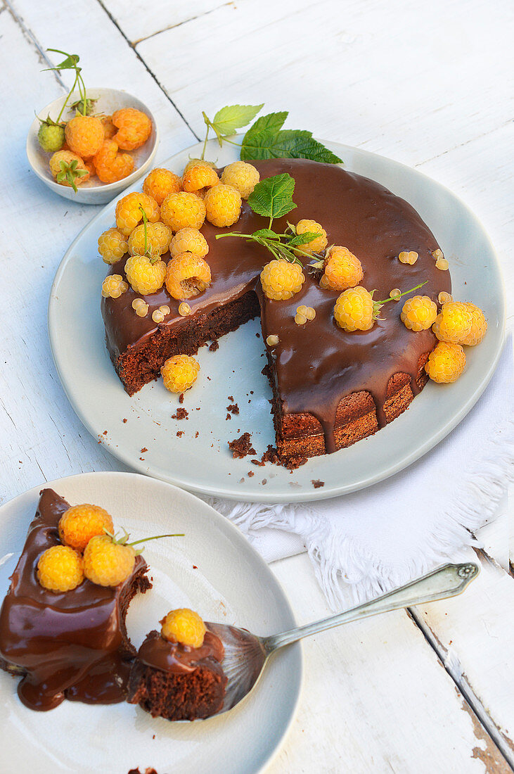 Saftiger Schokoladenkuchen mit gelben Himbeeren, angeschnitten