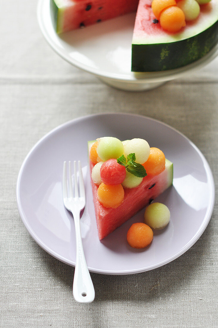 A piece of watermelon and melon balls