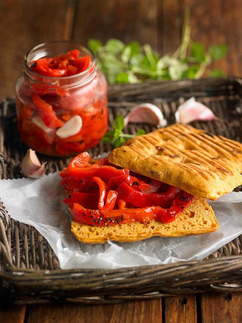 Jar Of Grilled Peppers With Herbs And Garlic And Sandwich