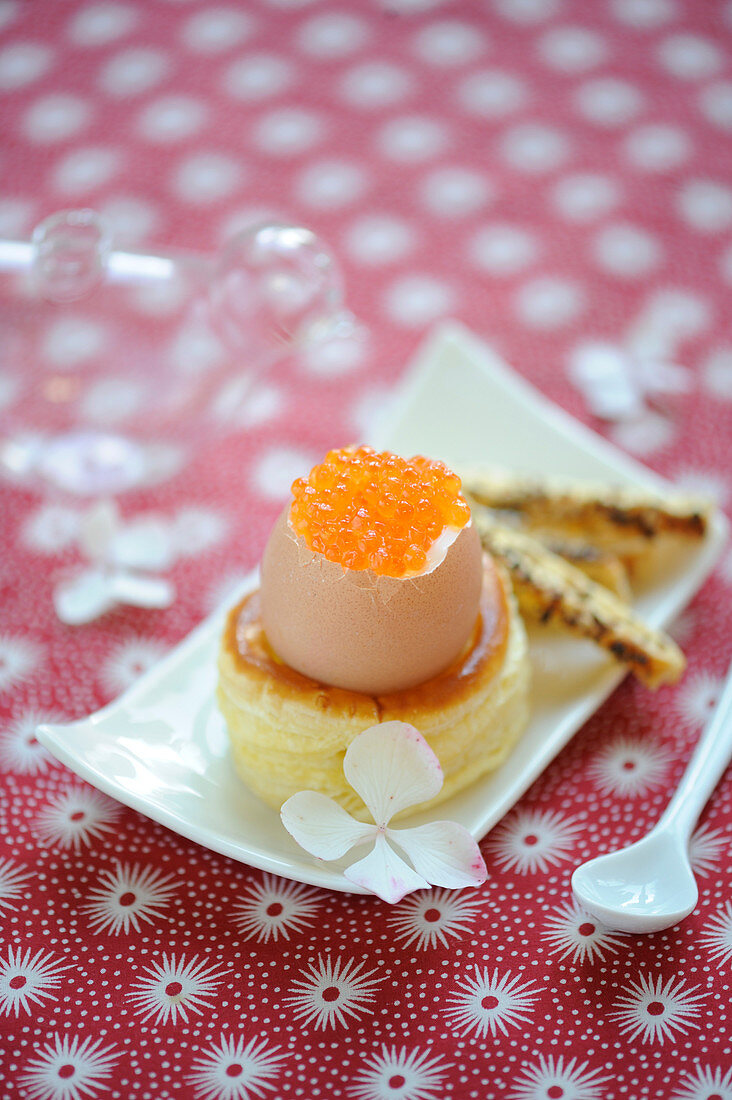 Soft-boiled egg with salmon roe placed on a Bouchée à la reine