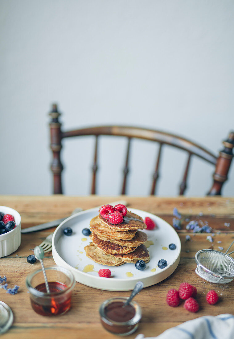 Pile of pancakes with raspberries,blueberries and maple syrup