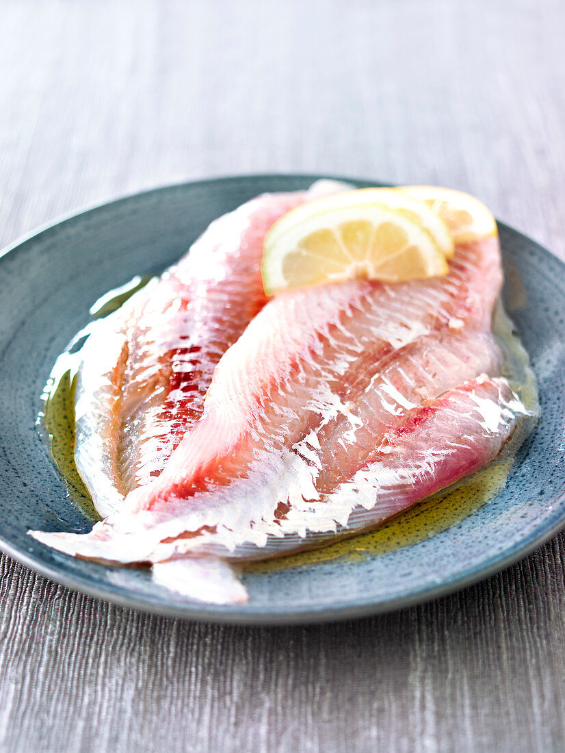 Raw pout fillets with coarse salt and olive oil