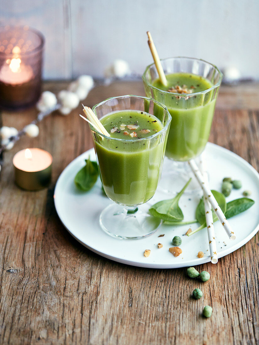 Glasses of spinach and pea juice with pepper and dried fruit crumbs