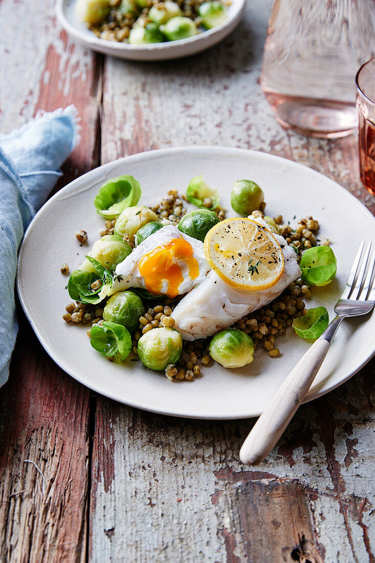 Piece of cod and poached eggs with lemon,Brussels sprouts and green lentil salad
