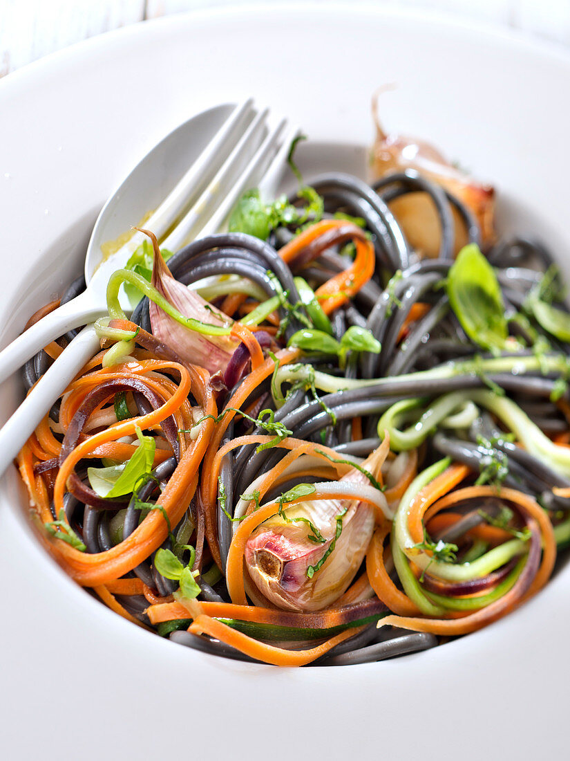 Mixed squid ink and vegetable spaghettis with garlic and basil