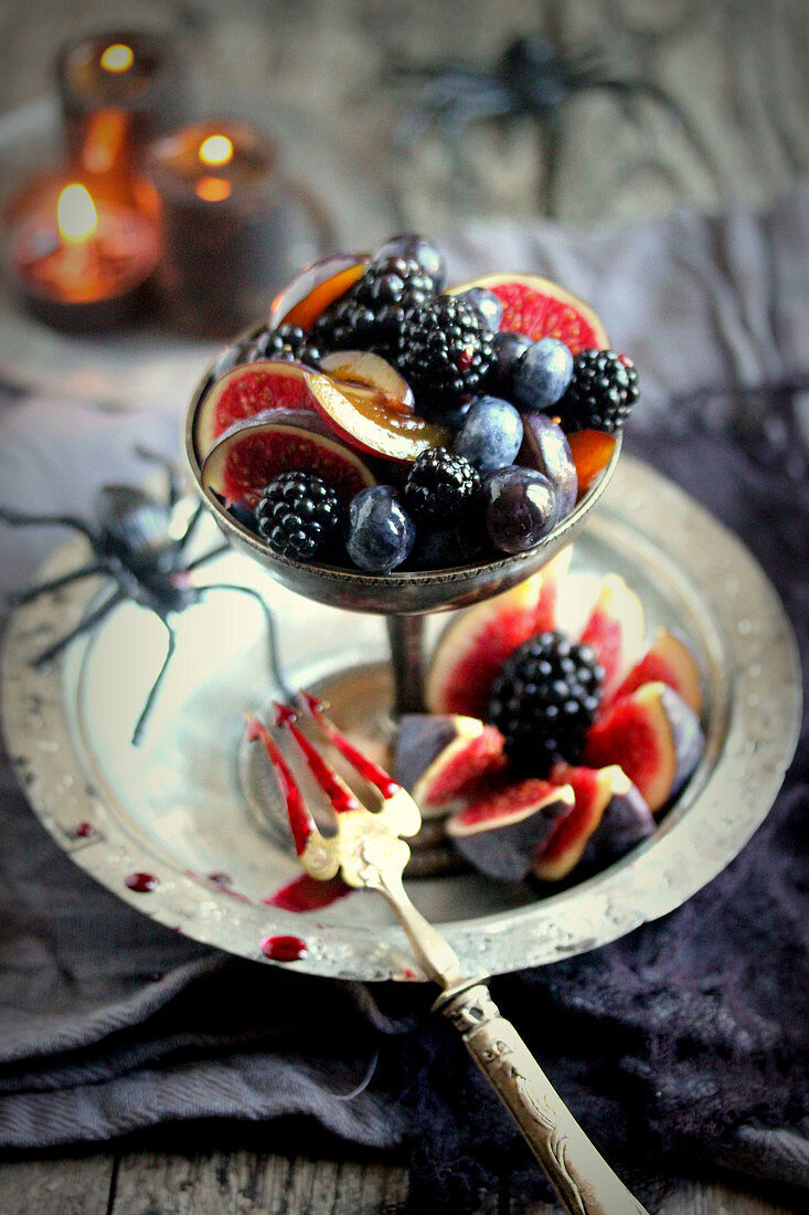 Obstsalat mit schwarzen und roten Früchten zu Halloween