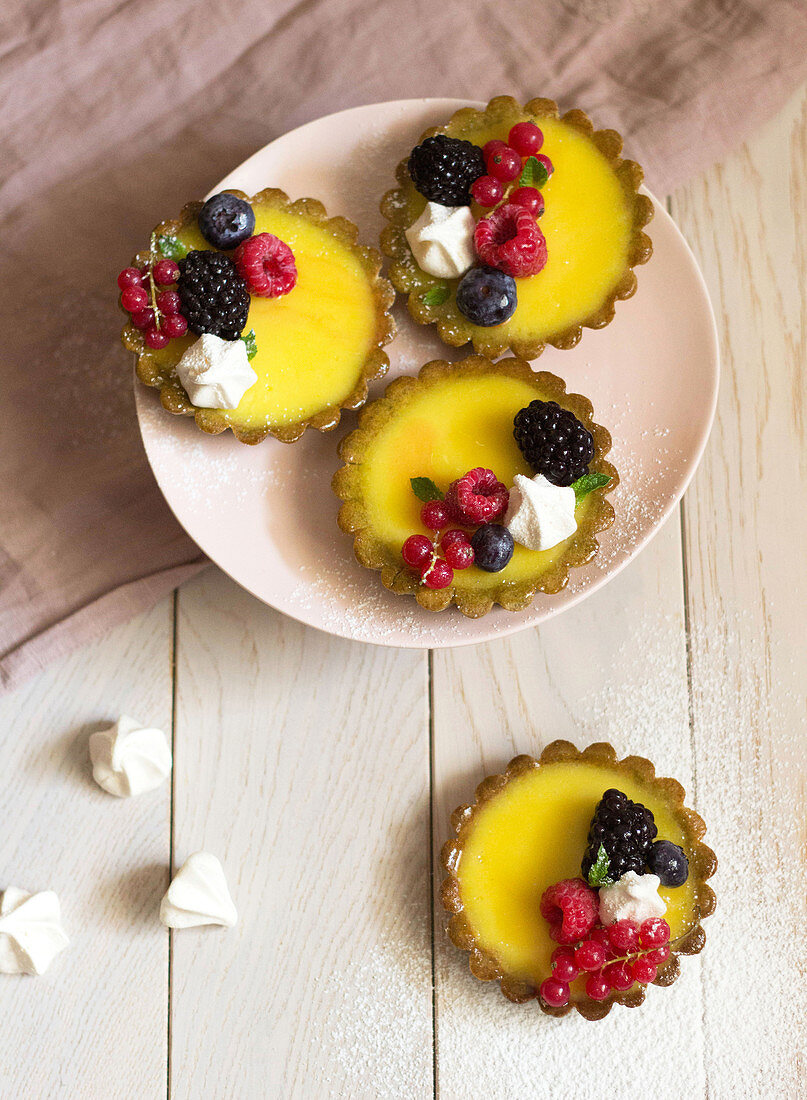 Zitronentörtchen mit Waldfrüchten und Baisertupfen