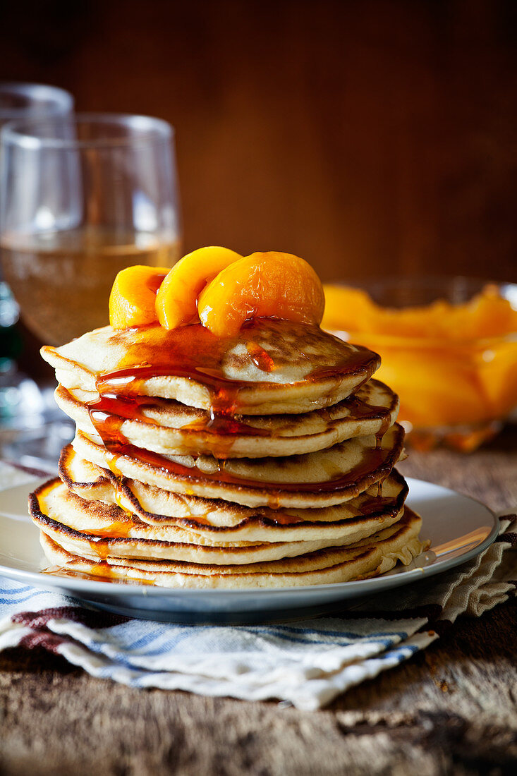 Stapel hausgemachte Pancakes mit pochierten Pfirsichen