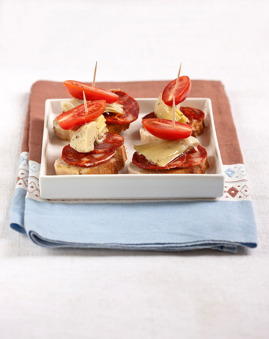 Pintxo (baskisches Brothäppchen) mit Chorizo, Artischocke und Tomate