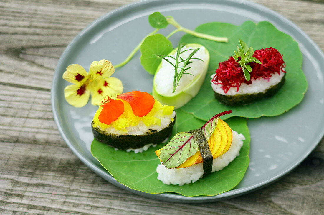 Maki und Nigiri Sushi mit Meerrettich, Kapuzinerkresse, Rucola und Roter Bete