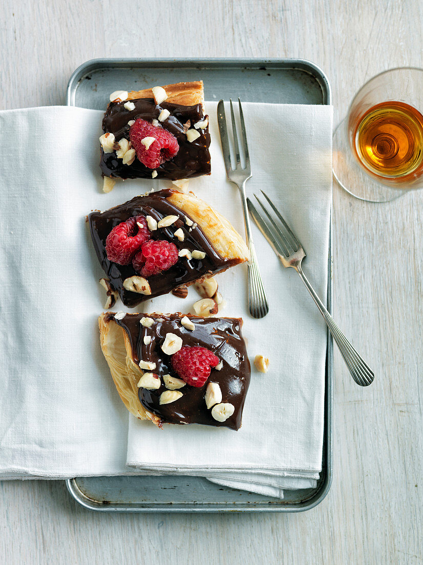 Blätterteiggebäck mit Schokolade, Himbeeren und gehackten Haselnüssen