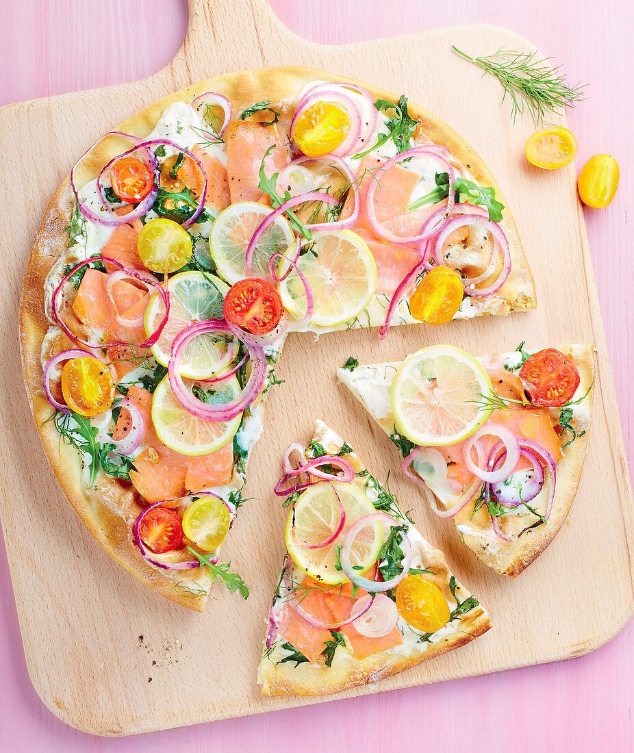 weiße Pizza mit Lachs, Kirschtomaten, Zitrone und Rucola