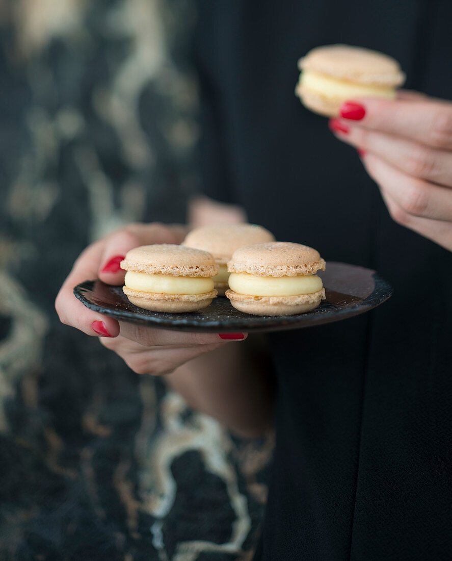 Woman holding a plate of Macarons