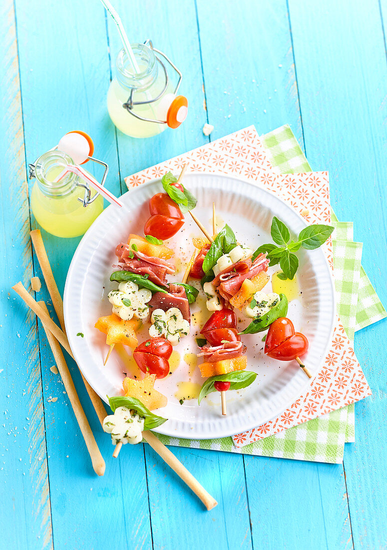 Spieße mit Tomate, Mozzarella, Schinken und Melone