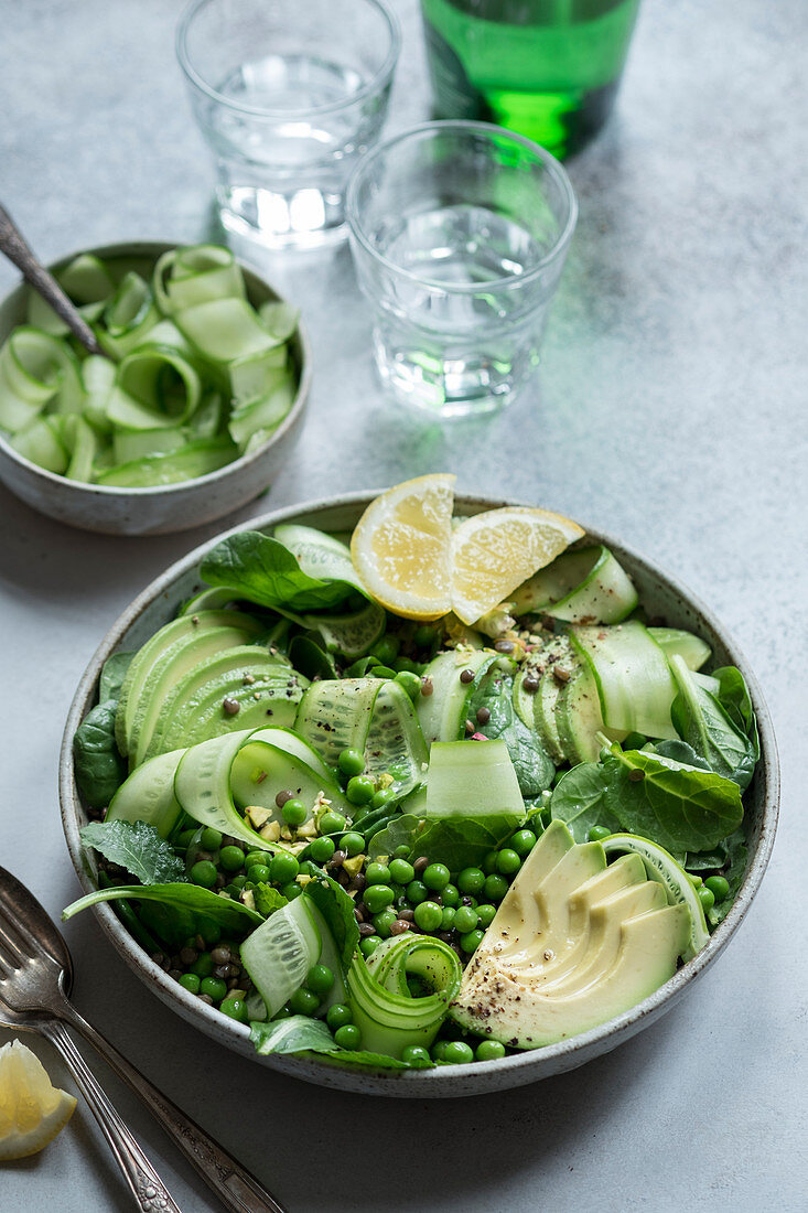 Grüner Salat mit Puylinsen, Erbsen, Gurken, Avocado und Spinat