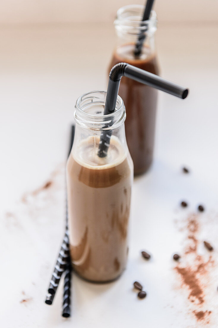 Eiskaffee-Cocktails serviert in Glasflaschen mit Strohhalmen