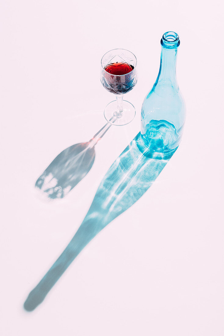 Glas Wein und blaue Flasche