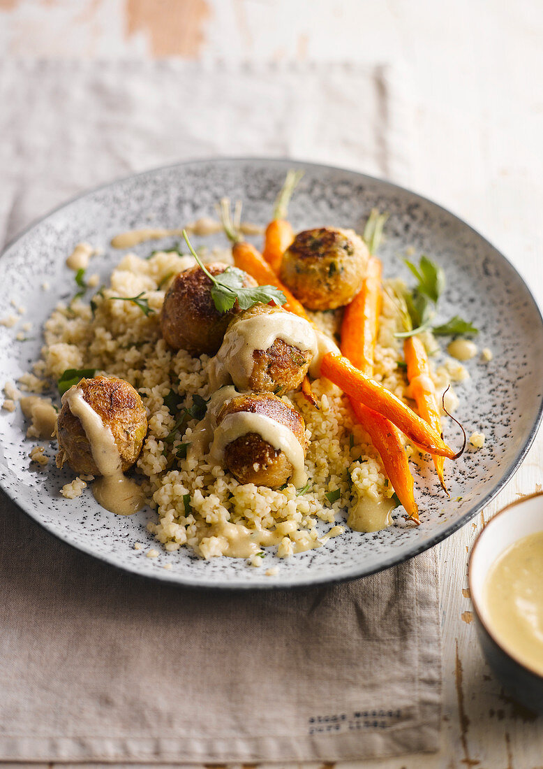 Chicken meatballs with young carrots on bulgur