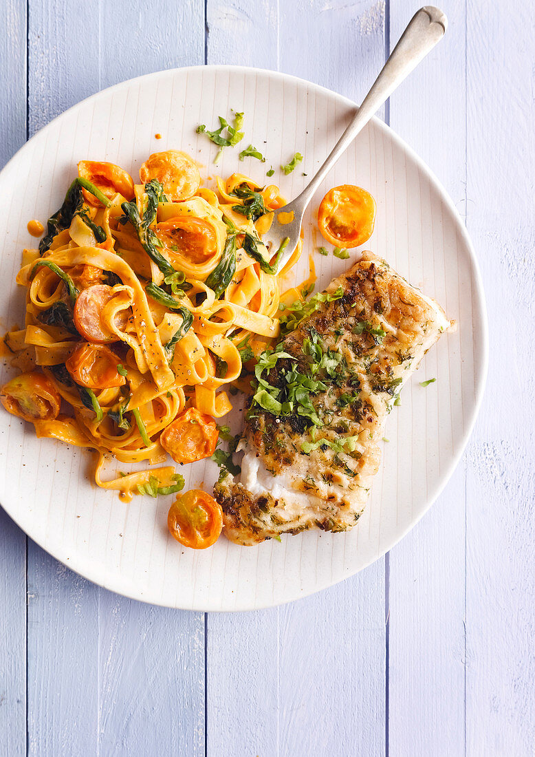 Fried fish fillet served with ribbon noodles with tomato cream sauce