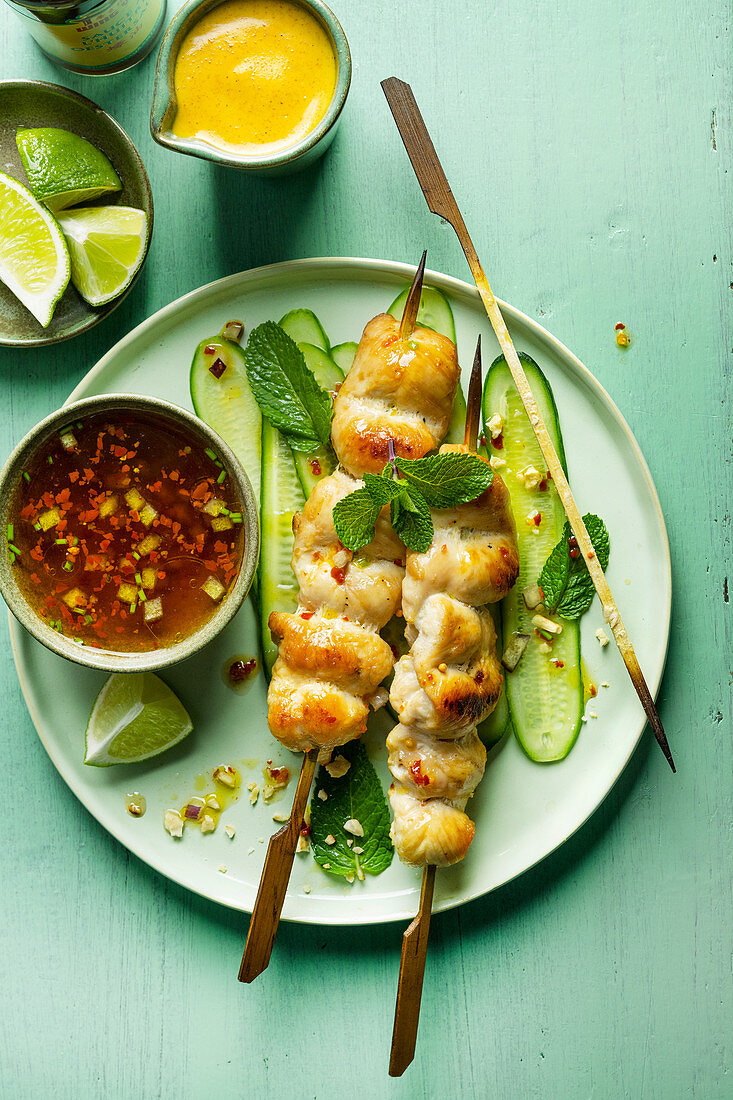 Thai chicken skewers on cucumber strips with chilli sauce