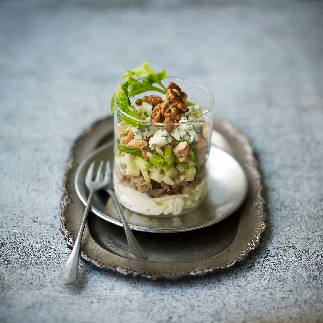 Layered salad with celery, tuna, gorgonzola and walnuts