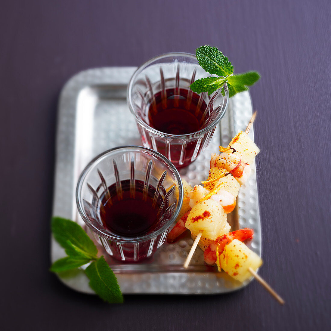 Cider and blackberry cocktails with pineapple and prawn skewers