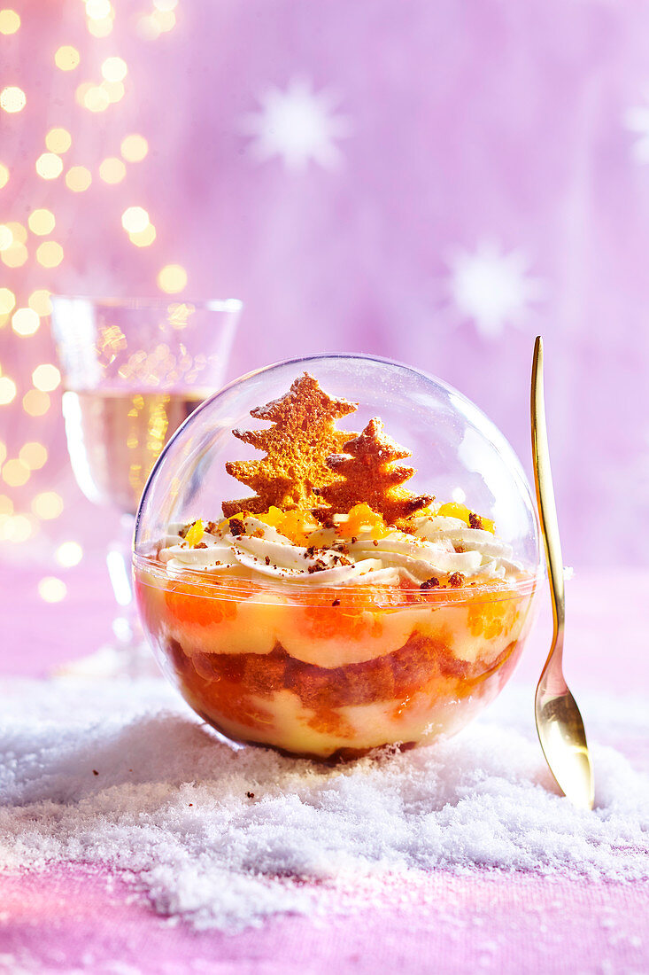 Weihnachtliches Clementinen-Trifle serviert in Schneekugel