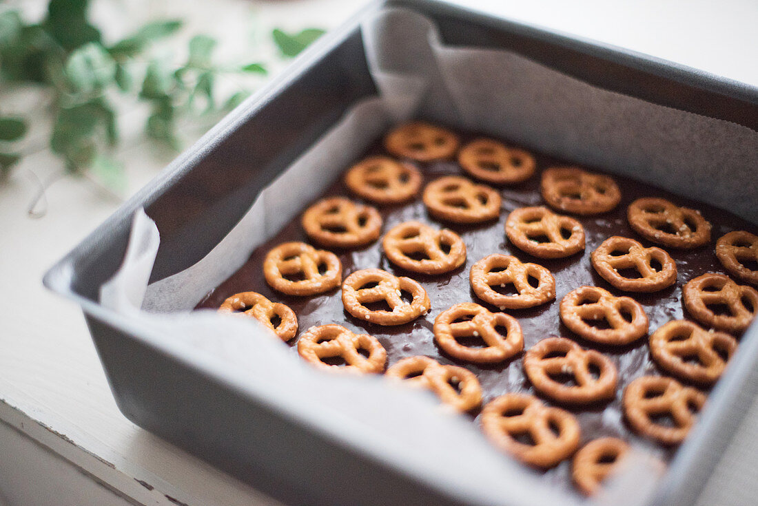 Brownie with salted pretzels in a baking tin
