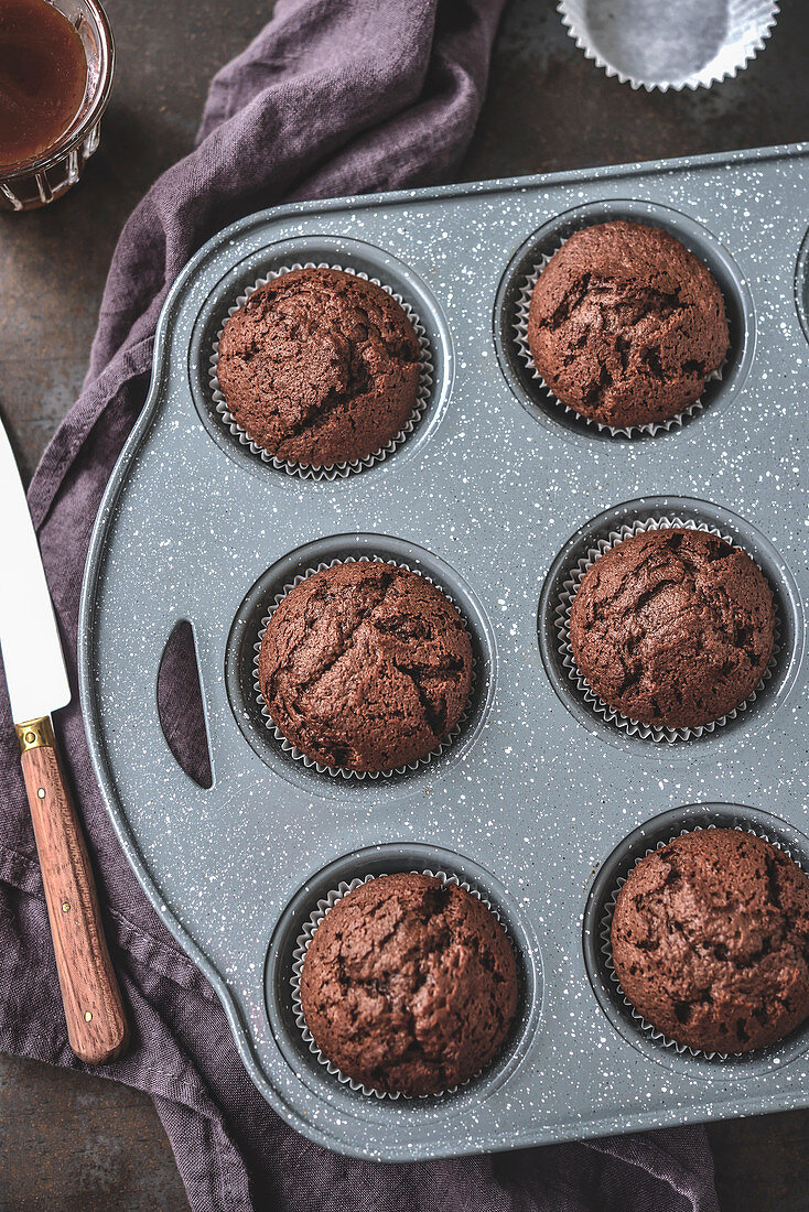 Chocolate muffins with a liquid caramel centre in a muffin tin