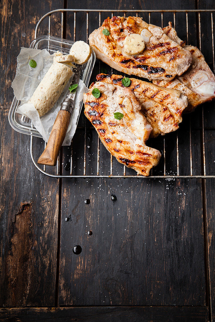 Grilled leg of lamb in slices on a grill rack with anchovy butter