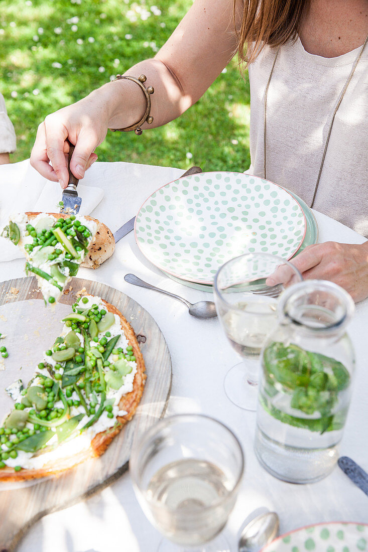 Cream cheese tart with green vegetables on an outdoor table