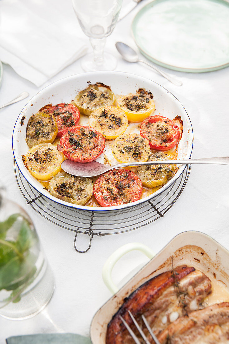 Überbackene gelbe und rote Tomatenscheiben auf provenzalische Art