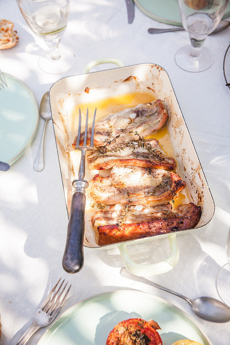 Oven-grilled pork chops with rosemary in the puree on a summery outdoor table