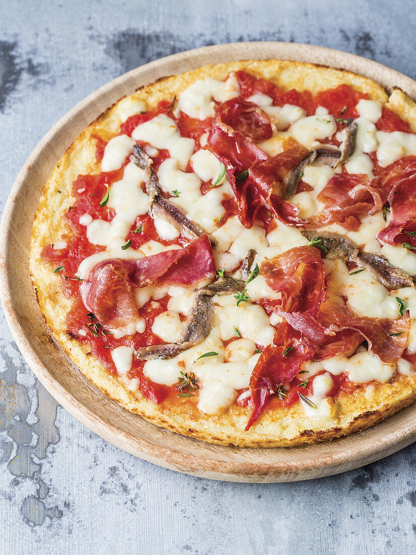 Blumenkohlpizza mit Käse, Sardellen, Tomaten und Rohschinken