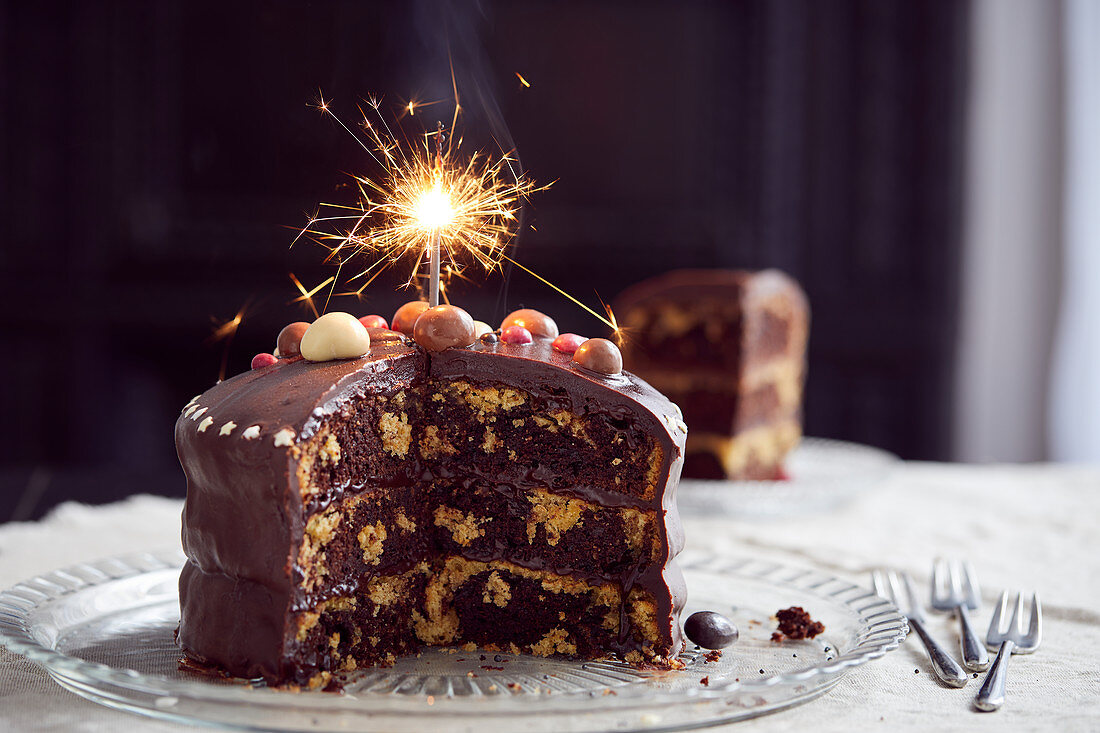 Three-layer chocolate marble cake decorated with sparklers