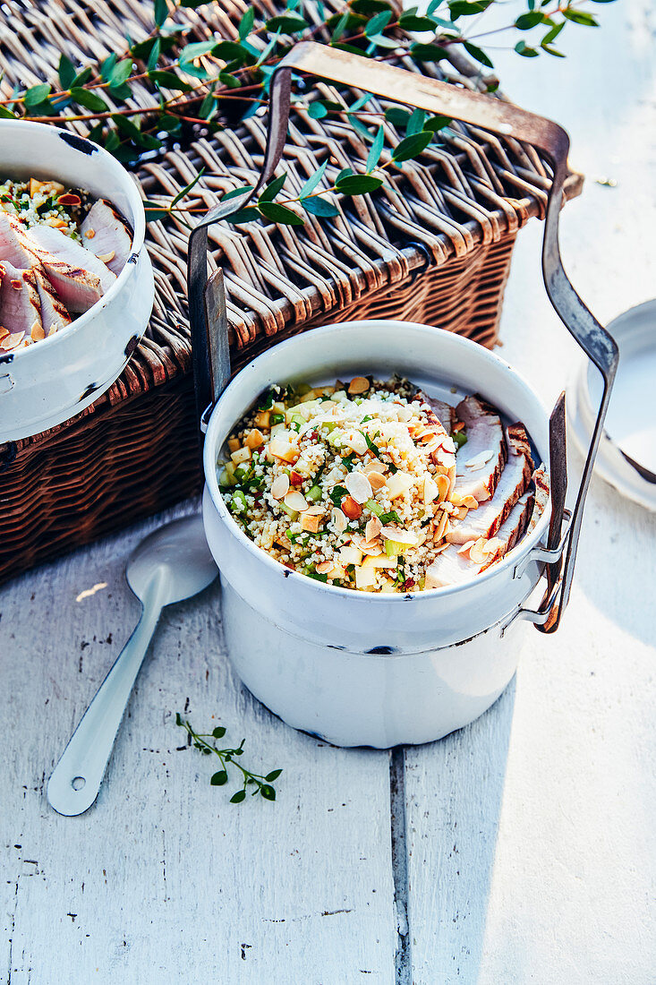 A picnic basket with vegetable tabbouleh with almond flakes and cold chicken breast