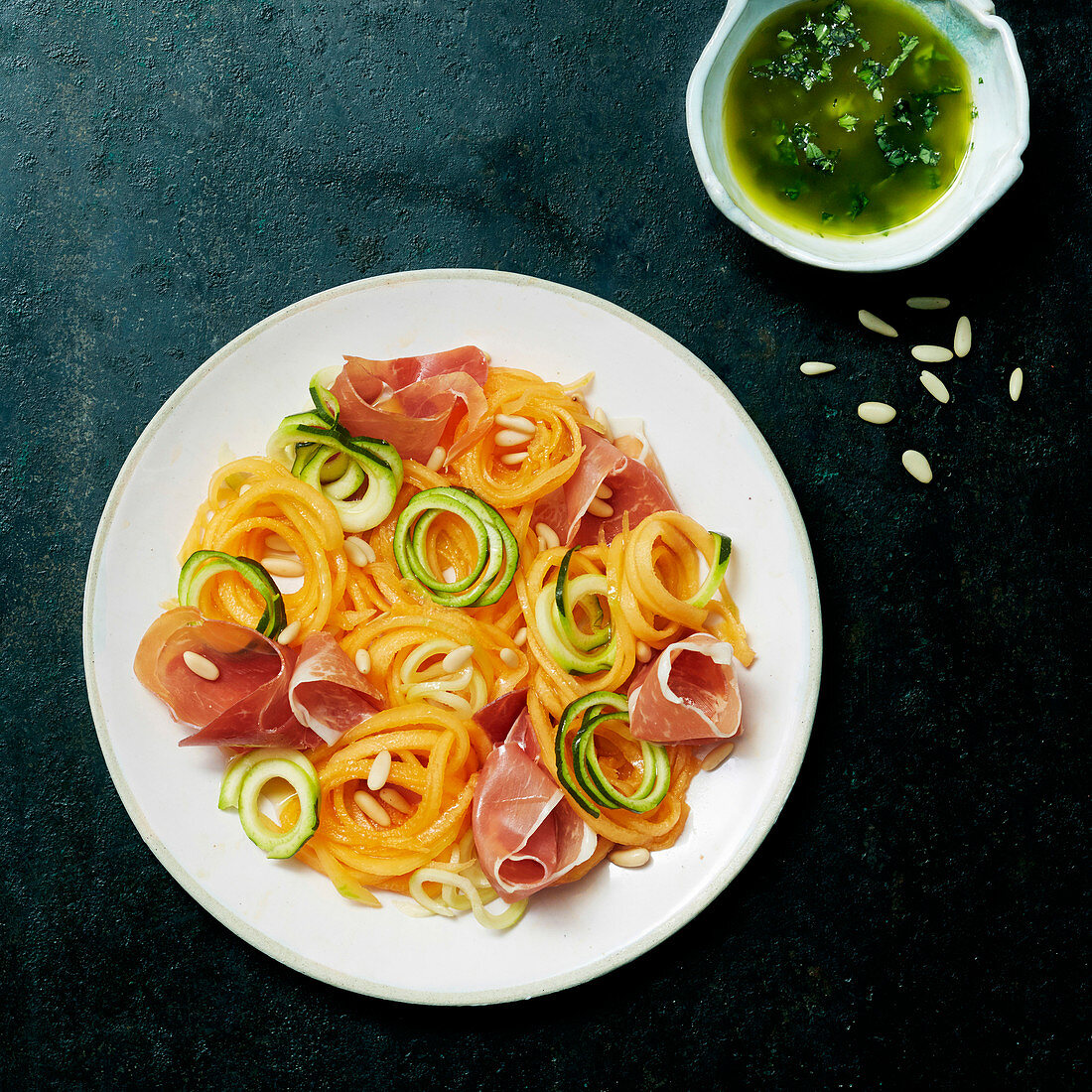 Courgette and carrot spaghetti with ham and herb sauce