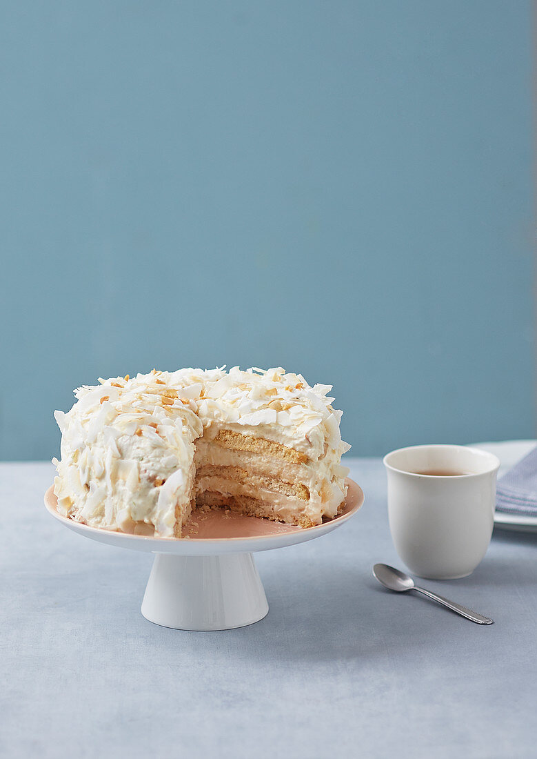 White chocolate cream cake, sliced on a cake stand