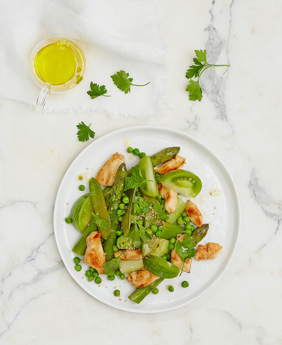 Chicken salad with green asparagus, peas and green tomatoes