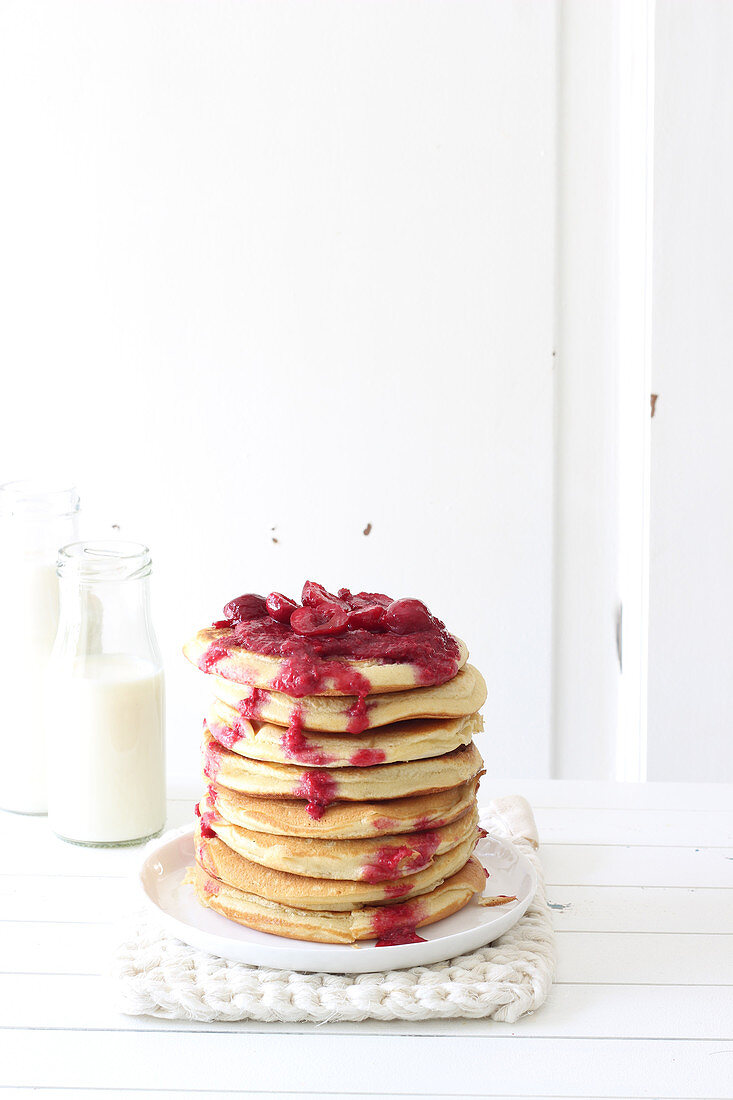 A stack of pancakes with cherry compote