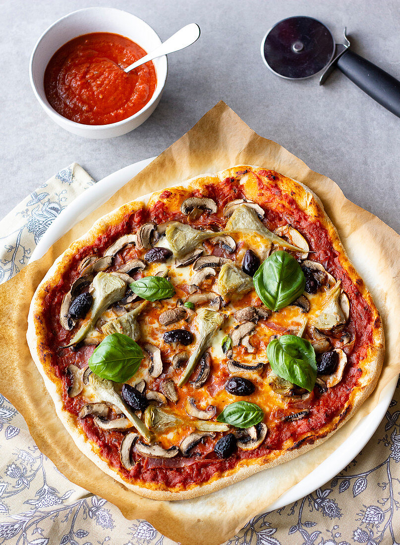 'Four Seasons' pizza with tomatoes, ham, mushrooms and artichokes