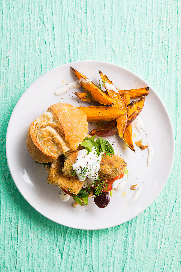 Homemade fish burger with fried sweet potato wedges