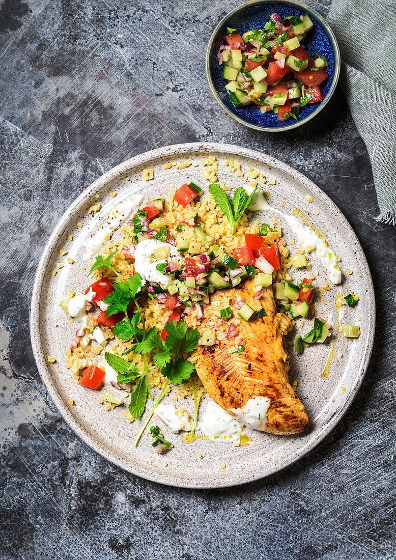 Chicken fillet on couscous salad with tomatoes and cucumber