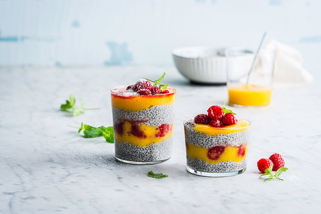 Layered desserts with chia pudding, mango and raspberries