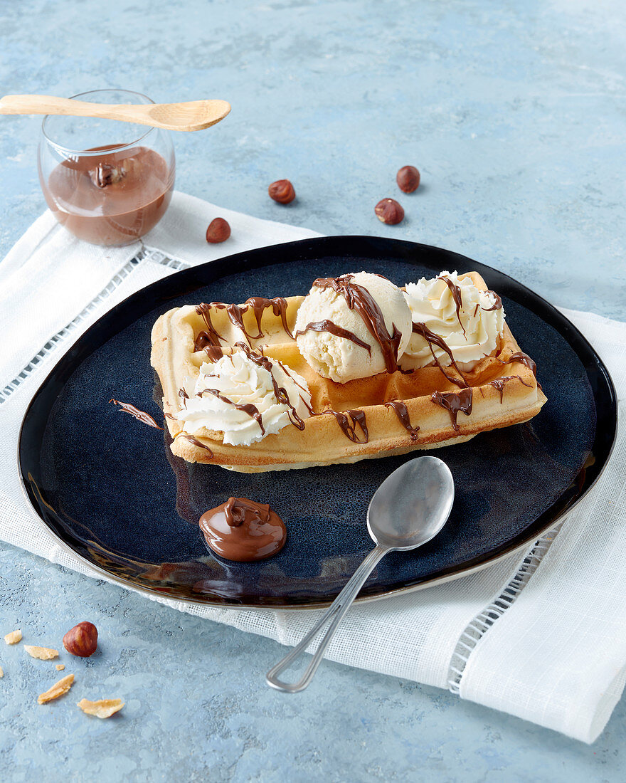 Waffle with vanilla ice cream, whipped cream and nut nougat cream