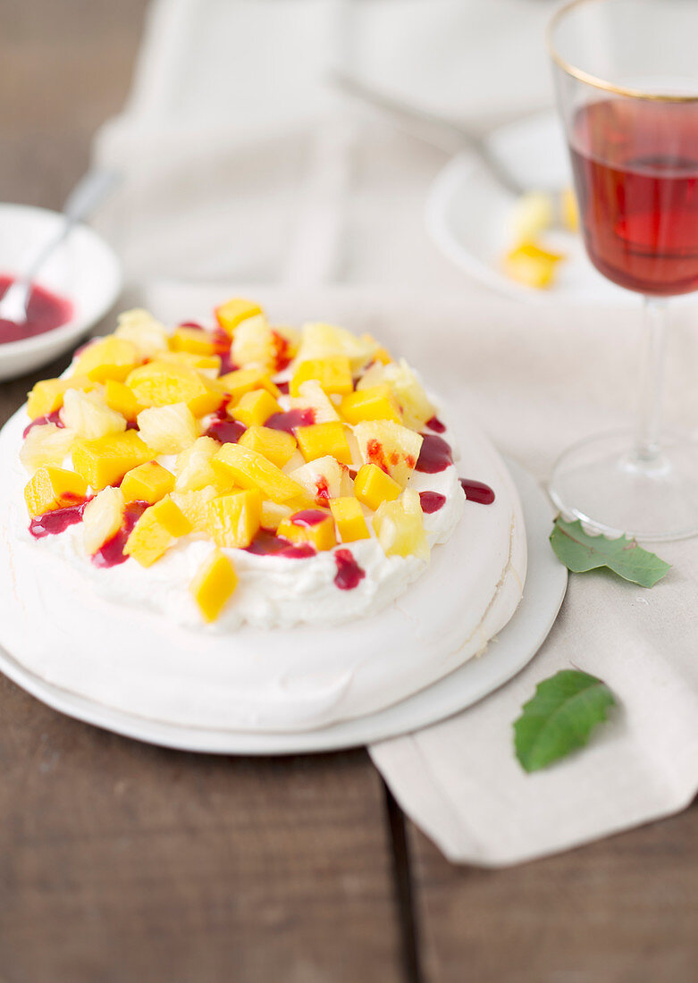 Pavlova mit Mango, Ananas und Beerencoulis