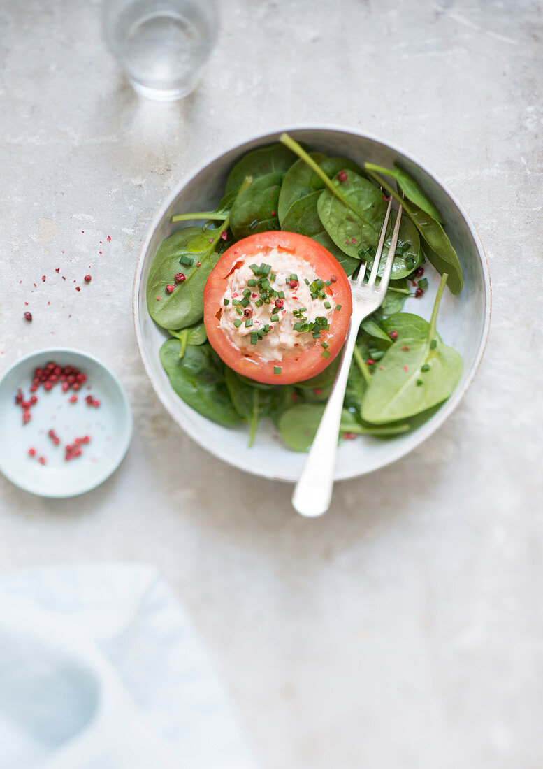 Stuffed tomato with processed cheese and spinach leaves